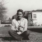 Vintage Snapshot Photo 1940s Man Sitting Cross Legged Holding Cat Kitten B w