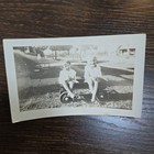 Vintage B w Photo Snapshot Of 2 Young Kids Sitting In Small Wagon In Front Yard