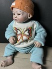 Soft Body Cloth Baby Doll  Light Complexion  Brown Eyes  No Hair  Outfit Hat