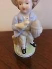 Porcelain Figurine Vintage Hand Painted Colonial Boy Holding Yellow Bird   Cage