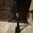Black Airsoft Rifle With Orange Tip And Blue Grip