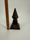 A Dark Iron Decorative Finial With A Stepped Base 