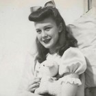Vintage Snapshot Photo Young Woman Bow Hair Stuffed Toy Bed Portrait 1940s
